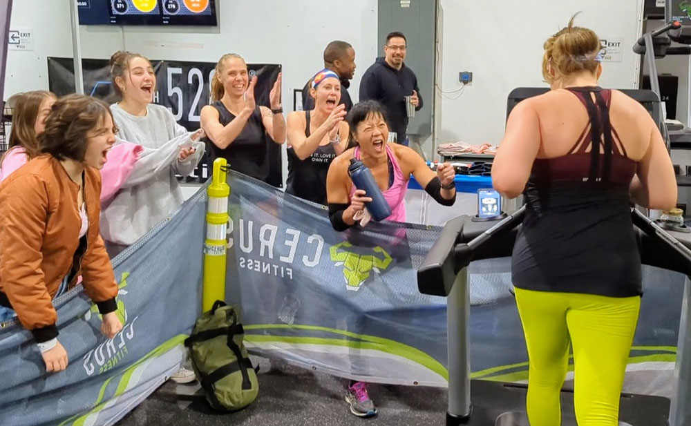 Crowd cheering woman running at Cerus Fitness